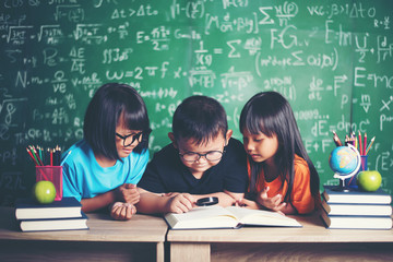 pupils  reading a book in the classroom.