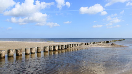 Baltic Sea During Springtime With wooden Groynes And Reflection