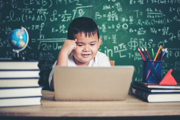 kid  use computer laptop  in the classroom.