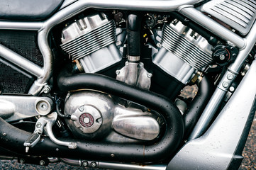 Fototapeta na wymiar Closeup of motorbike with lots of chrome details. Modern powerful perfomance road motorcycle shiny reflexive surface engine with exhaust pipes. Vehicle industry. Two-wheeled vehicle technologies.
