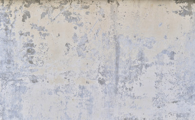 Part of the concrete wall with loose plaster of the old building. Background.