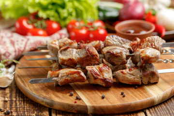 Juicy kebabs from pork. Meat cooked on open fire and fresh vegetables.