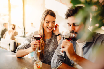 Blonde girl is drinking wine with her boyfriend in cafe