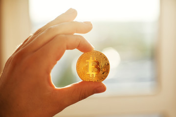 hand holding shiny golden bitcoin in light, gold money. digital currency, bit coin in people hands, cryptocurrency concept.space for text, money modern investment. rich  network currency