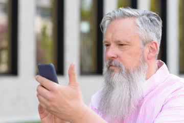 Attractive bearded man reading a text message