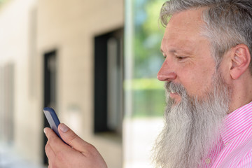 Attractive bearded man reading a text message