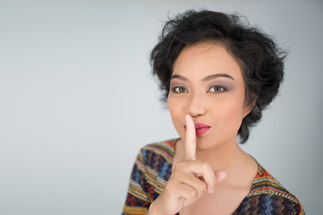 Fototapeta premium Young girl making silence gesture on white background