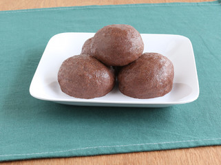 Ragi or finger millet balls, which are a healthy southern Indian food, in a ceramic tray.