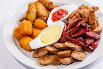 Grilled sausages on a plate with sauce