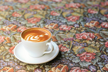 Coffee Latte on vintage tablecloth in morning