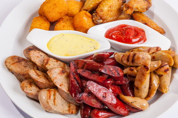 Grilled sausages on a plate with sauce