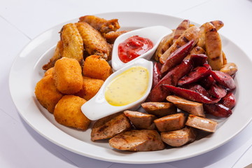 Grilled sausages on a plate with sauce