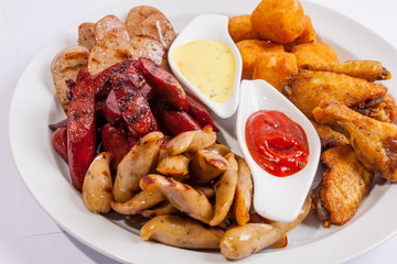 Grilled sausages on a plate with sauce