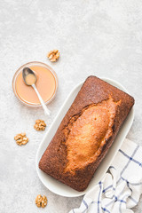 Cinnamon condensed milk pound cake on light concrete background. Top view, space for text.