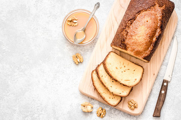 Nut chocolate pound cake on light concrete background. Top view, space for text.