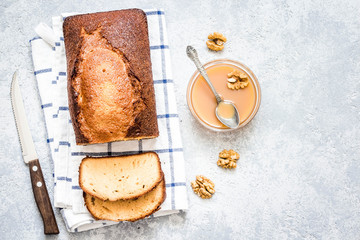 Caramel walnut ginger pound cake on light concrete background. Top view, space for text.