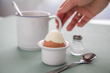 Frau hat gekochtes Ei und Kaffee zum Frühstück