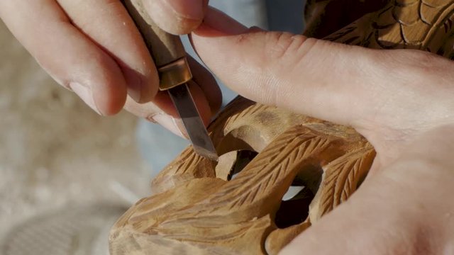 close up of working woodcarver, male carpenter in workshop 