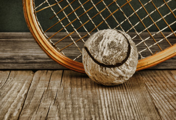old tennis ball and racket on a wooden floor