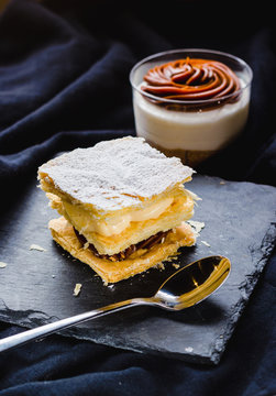 Close up of puff pastry and dessert with cream in cup