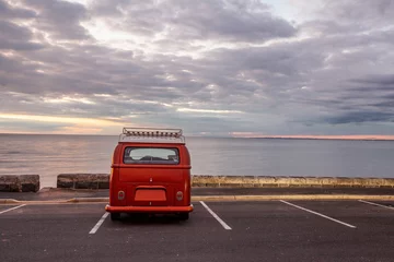 Papier Peint photo Plage de Camps Bay, Le Cap, Afrique du Sud Vintage minivan on empty parking lot at the beach at sunset