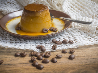 Coffee flan in a plate on wood background