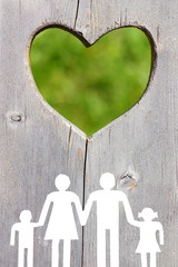 Family on wooden background with green heart welfare concept