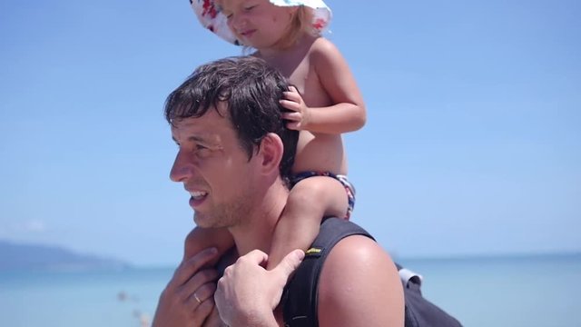 A little daughter sits on her father's shoulders. slow motion, 1920x1080, full hd