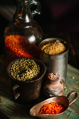 Still life with different containers for grain on wood background