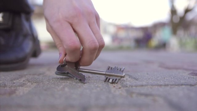girl finds lost keys on the street sunny weather