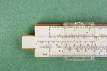 slide rule on a green background