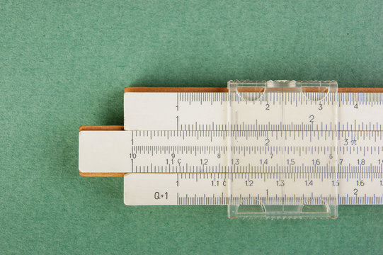 slide rule on a green background