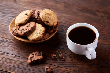 Coffee cup, jar with coffee beans, cookies over rustic background, selective focus, close-up, top view