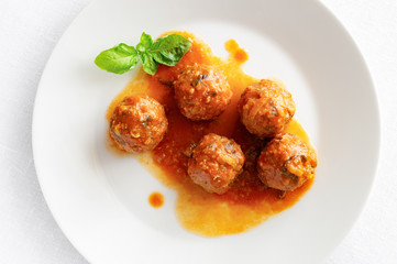 beef meatballs cooked with rice in tomato sauce decorated with basil
