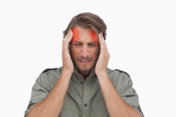 Man wincing with pain of headache on white background