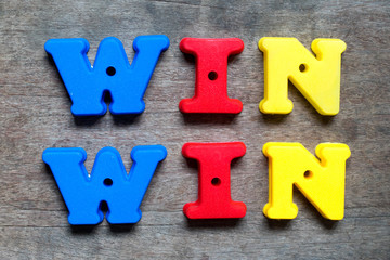 Obraz premium Color alphabet in word win win on wood background