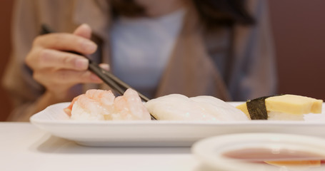 Obraz na płótnie Canvas Woman having sushi in Japanese restaurant