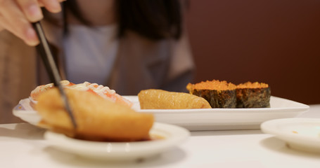 Woman having Japanese sushi in restaurant