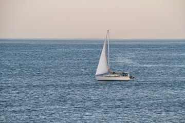 Obraz premium A sailboat at sea in the open ocean in the late afternoon.