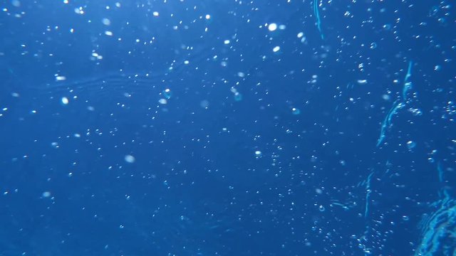 Sunlight passes through water column. Air bubbles rise to surface of water. Sea. Underwater video shooting. Undersea world.