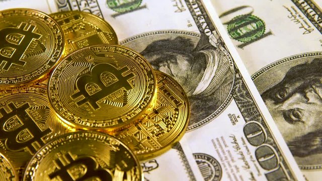 Lot of Bitcoins btc bit-coin lie on hundred-dollar bills of United States. Rotation. Mining. Cryptocurrency. Economy. Cyberspace. Background.
