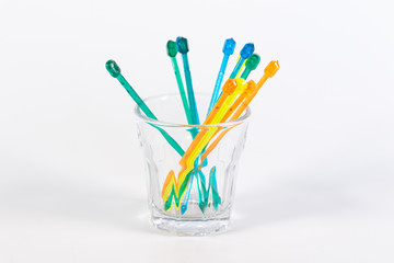 Farbige Käsepicker in einem klaren Schnapsglas isoliert vor weißem Hintergrund