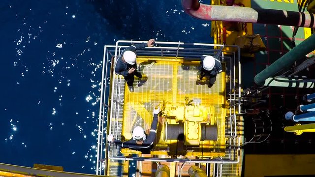Men hammering stuck winch operation of life boat offshore