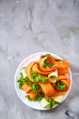 Artistically served vegetable salad with carrot, cucumber, letucce over white background, selective focus