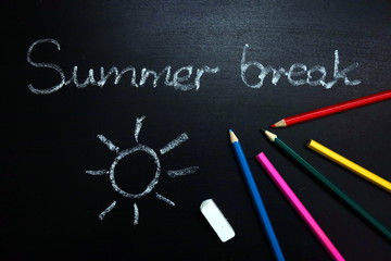 Fototapeta na wymiar Summer break text and sun drawing on chalkboard, end of school year concept