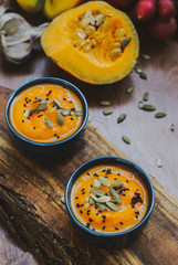 Homemade vegetable soup with pumpkin with cream and black sesame, top view with copy space