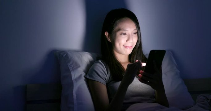 Woman use of cellphone on bed