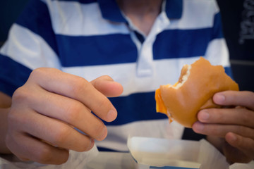 blur man hand holding bite burger on table