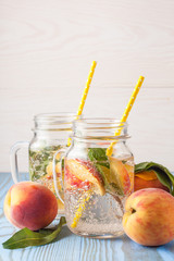 Homemade lemonade of ripe peaches and cold fresh mint. A jar of peach tea. Refreshing water.