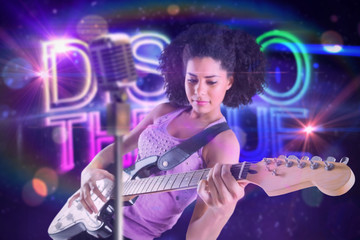 Pretty girl playing guitar against digitally generated colourful discotheque text